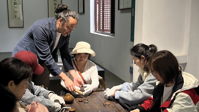 王伯杨为市民讲解培训桂林柚器制作技艺.jpg